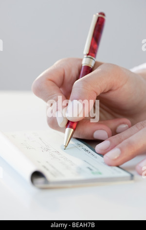 Frau schreiben Barscheck Stockfoto