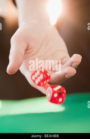 Frau, die Würfel zu werfen Stockfoto
