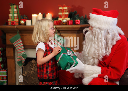 Santa Claus gibt jungen Mädchen Weihnachtsgeschenk Stockfoto