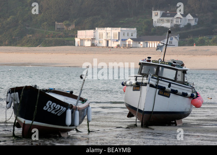 Angelboote/Fischerboote bei Ebbe in St Ives Harbour mit dem Porthminster Café und Strand im Hintergrund Stockfoto