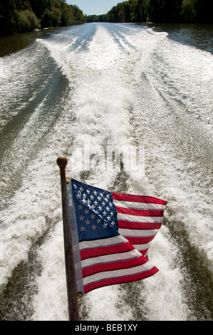 Vom Wind verwehten US-Flagge in Motorboote wecken. Stockfoto