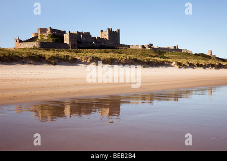 Bamburgh Castle spiegelt sich in den nassen Sand auf leeren Strand Vorland. Bamburgh, Northumberland, England, Großbritannien, Großbritannien Stockfoto