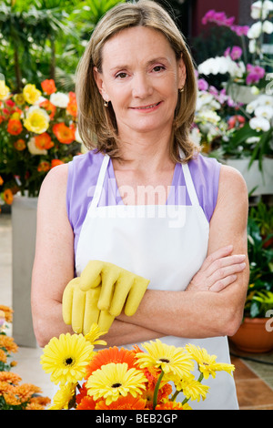 Frau, die Arme gekreuzt in einem Gewächshaus Stockfoto