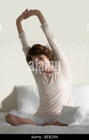 Frau auf dem Bett dehnen Stockfoto