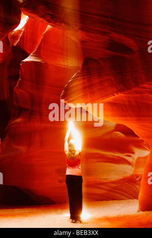 Sonnenstrahl fällt auf eine Frau in einem Canyon, Antelope Canyon, Page, Arizona, USA Stockfoto