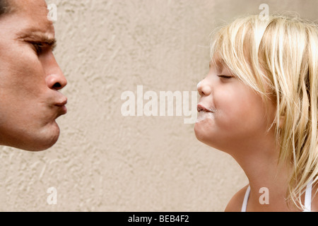 Mann seine Lippen kräuseln, seine Tochter zu küssen Stockfoto