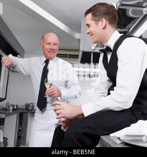 Zwei Kellner Weintrinken in der Küche Stockfoto