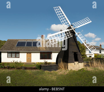 Englischen Cottage ausgestattet mit Sonnenkollektoren und alte Windmühle England UK Stockfoto