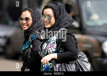 Junge moderne muslimische Frauen in bunten traditionellen Kleid, Mayfair, London, UK Stockfoto