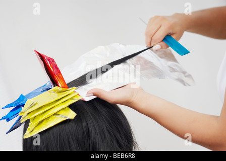Nahaufnahme eines Friseurs Hände eine Person die Haare färben Stockfoto