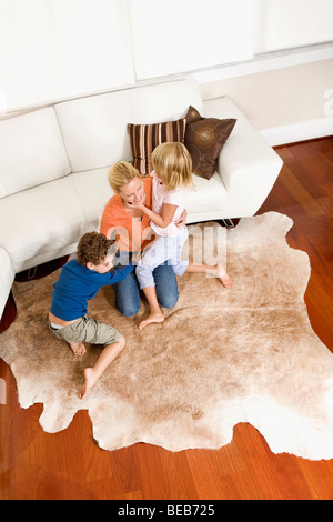 Frau spielt mit ihrem Sohn und eine Tochter in einem Wohnzimmer Stockfoto