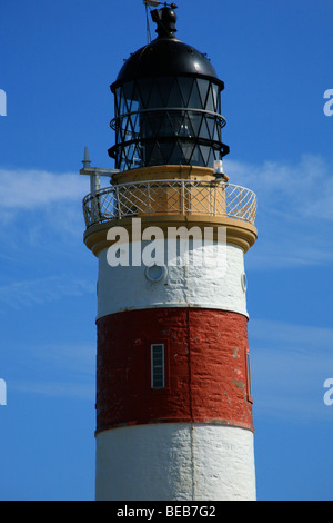 Nahaufnahme von einem rot-weißen Leuchtturm vor blauem Himmel Stockfoto