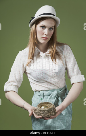 Porträt einer Frau mit ein goldenes Ei im Nest des Vogels Stockfoto