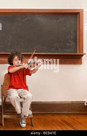 Schüler spielen eine Geige in einem Klassenzimmer Stockfoto