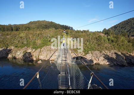 Person am Buller Gorge Swing Bridge, in der Nähe von Murchison, Tasman District, Südinsel, Neuseeland Stockfoto