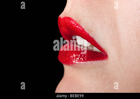 Die Lippen Frau vor einem schwarzen Hintergrund Stockfoto