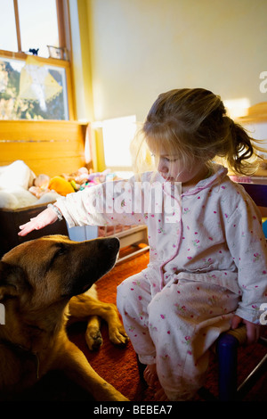 Babymädchen spielen mit einem Hund Stockfoto