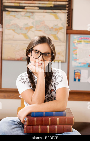 Schulmädchen mit Büchern in einem Klassenzimmer zu sitzen Stockfoto