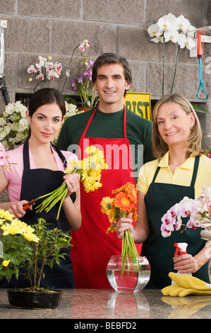 Zwei weibliche Floristen mit einem männlichen Blumenladen lächelnd Stockfoto