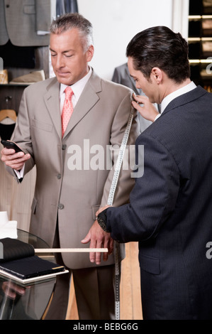 Schneider die Messungen eines Kunden Stockfoto