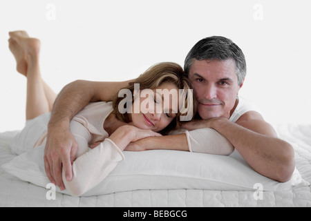 Paar auf dem Bett liegend und lächelnd Stockfoto