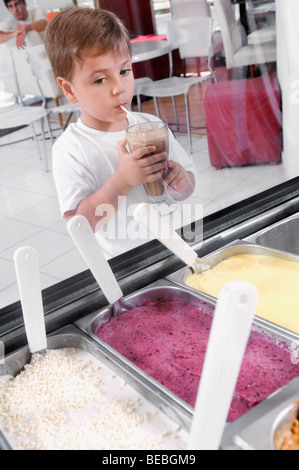 Junge Blick auf Eis beim Trinken Milchshake Stockfoto