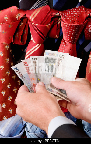 Geschäftsmann mit Banknoten in einem Bekleidungsgeschäft Stockfoto