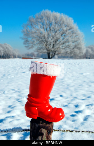Rote Stiefel vom Weihnachtsmann in Schneelandschaft Stockfoto