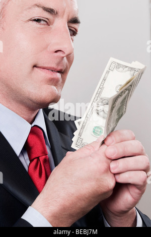 Geschäftsmann mit Banknoten in einem Bekleidungsgeschäft Stockfoto