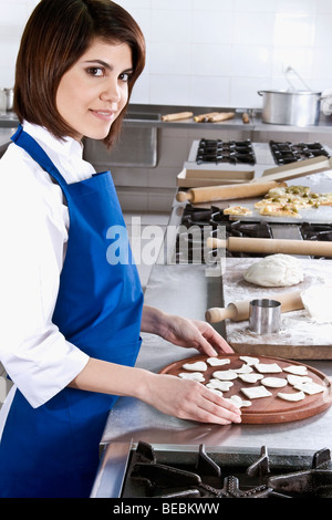 Köchin machen Cookies in der Küche Stockfoto
