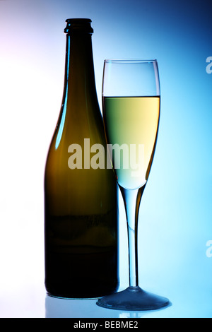 Flasche und Glas Champagner mit ambient kühlem Blau mit einem Hauch von rosa Hintergrundbeleuchtung Stockfoto