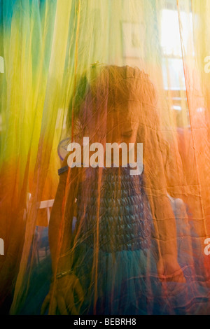 Babymädchen hinter einer Gardine Stockfoto