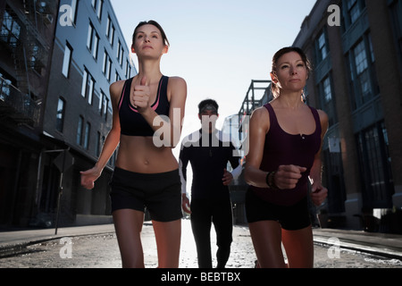 Zwei Frauen und ein Mann in einer Straße zum Joggen Stockfoto