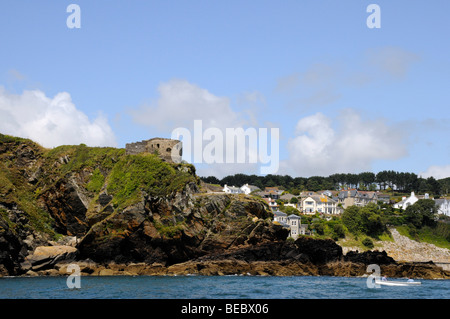 Zwei Männer Fische in einem kleinen Boot am Eingang zum Hafen von Fowey, Cornwall. Alte Befestigungsanlagen schützen Eintritt in der alten Hafenstadt. Stockfoto