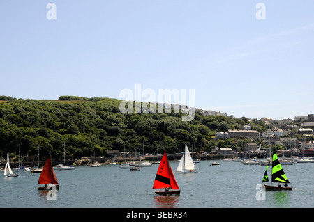 Segelunterricht auf Fowey Mündung, Segel zwei rote ein grünes Segel und weiße Segel im Hafen von traditionellen kornischen Dorf. Stockfoto