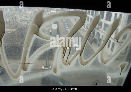 Ein Fenster in Graffiti bedeckt aus blickt man auf die Gebäude des trendigen Dumbo Stadtteils Brooklyn in New York Stockfoto