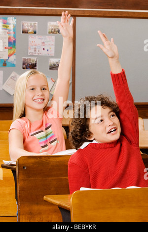Studenten, die ihre Hände in einem Klassenzimmer Stockfoto