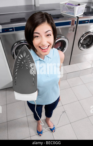 Porträt einer Frau hält Eisen und lächelnd Stockfoto