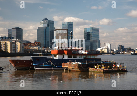 Alte Schiffe auf der Themse mit den Türmen der Canary wharf im Hintergrund Stockfoto