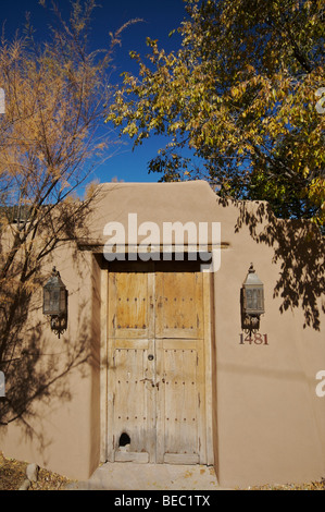 Holztür in einem alten Adobe-Stuck-Wand an einem Haus an der Upper Canyon Road in Santa Fe. Stockfoto