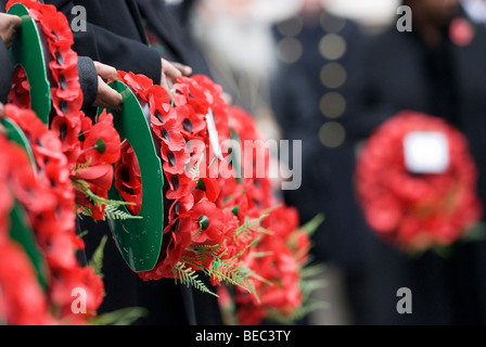 Menschen halten Mohn Kränze am Remembrance Day Sonntag an der Kenotaph, London. Stockfoto