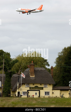 Einem Easyjet-Passagier-Jet über The Three Horseshoes Pub in Maulwurfshügel grün, Essex, auf dem Weg zum landen am Flughafen Stansted Stockfoto