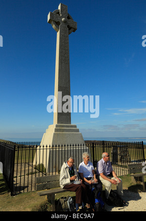 Ältere Menschen sitzen neben dem Tennyson-Monument. Tennyson Down, Isle Of Wight, England, Vereinigtes Königreich. Stockfoto