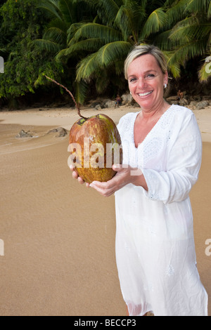 Frau mit einer Kokosnuss in ihr Hände, Insel Mahe, Seychellen, Indischer Ozean, Afrika Stockfoto