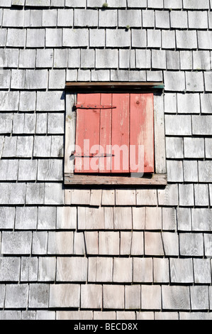 Roten Fensterläden Fenster auf Seite der verwitterte Holzschindeln Windmühle Stockfoto