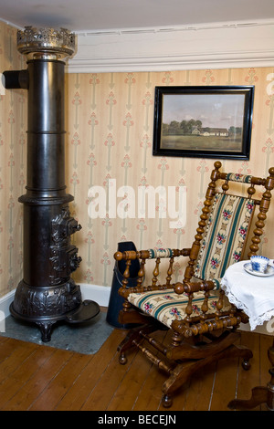 Alten Schaukelstuhl in einem Kaminofen Stockfoto