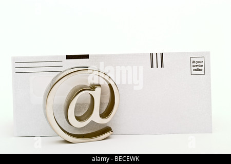 Metallische e-Mail-Symbol vor einem Papierumschlag Stockfoto