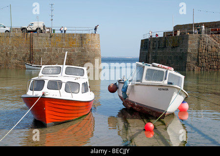 Zwei Boote bei Ebbe in Mousehole harbour in Cornwall UK. Stockfoto