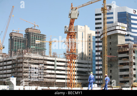 Zwei asiatische Arbeiter blicken über den Hochbau-Bereich in den neuen Bezirk von Doha, Katar, im Jahr 2007. Stockfoto