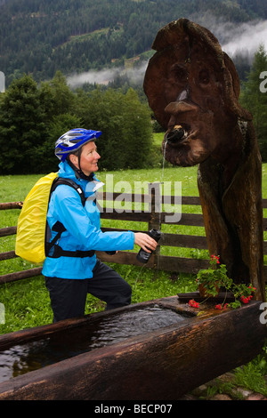 Weibliche Mountainbiker Nachfüllen ihrer Wasserflasche, Steiermark, Österreich Stockfoto